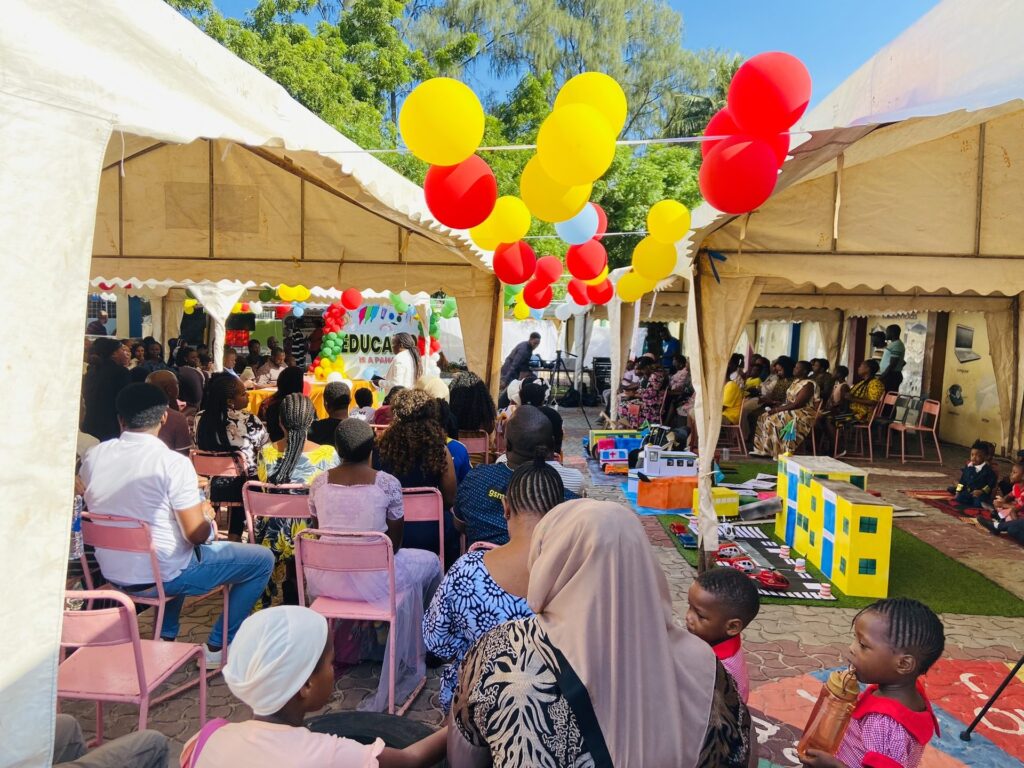 Parents fill the tents as the school grounds come alive with balloons.