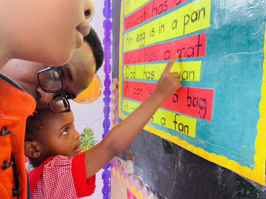 Pointing out sentences on the classroom reading wall.