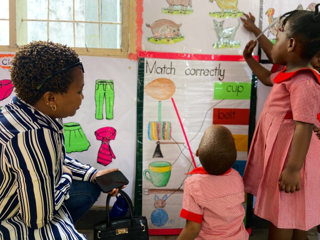 A parent watches learners tackle the matching chart.
