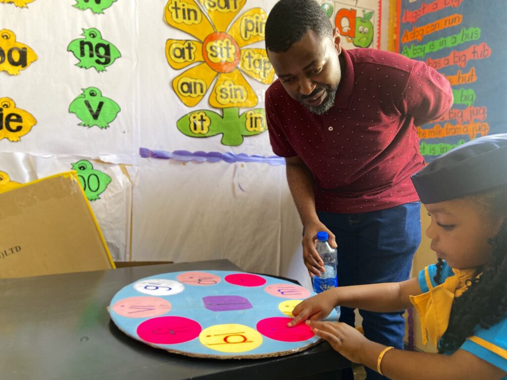 Father and daughter work through sounds on the phonics wheel.