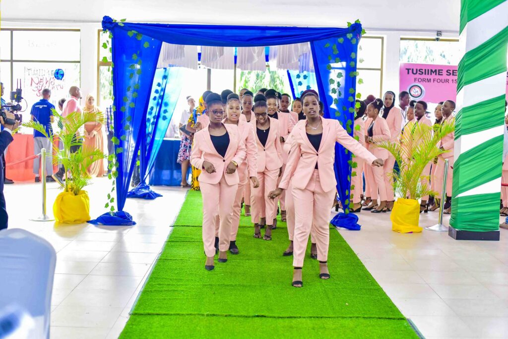 Leading the class in with a dance down the green carpet