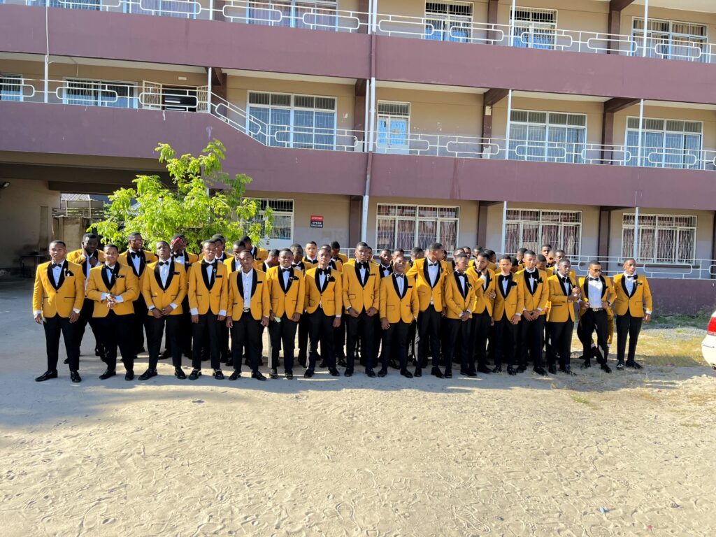 The graduating boys line up in their golden tuxedos