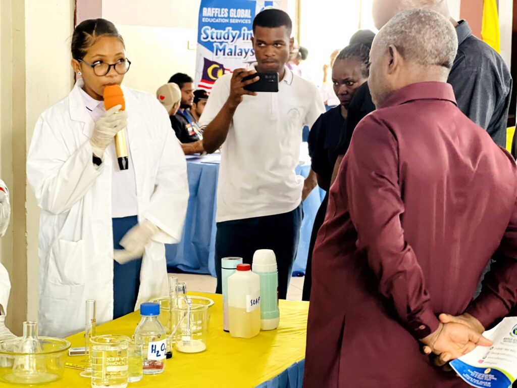 A student walks guests through a science demonstration