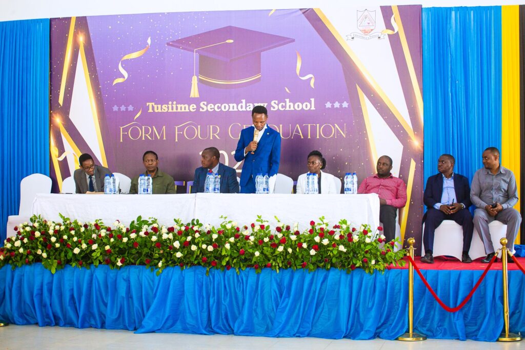The high table addresses graduates beneath the Form Four Graduation 2023 banner.