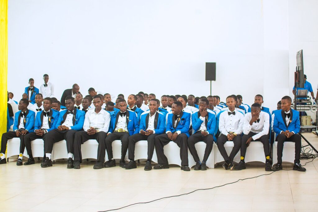 The graduating gentlemen seated smartly in their tuxedos.
