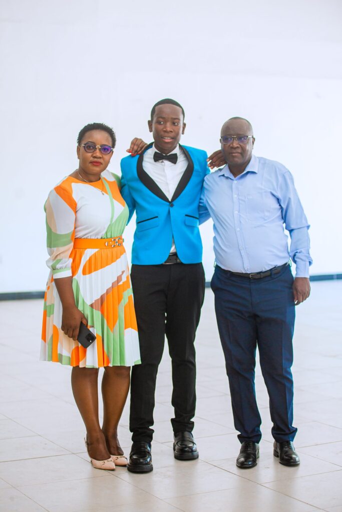 A graduate stands tall between his proud parents.