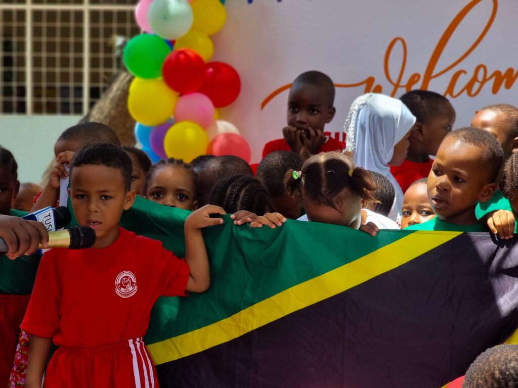 Singing proudly beside the Tanzanian flag
