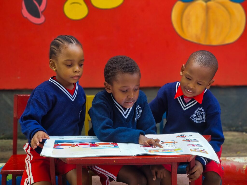 Three friends share a picture book.
